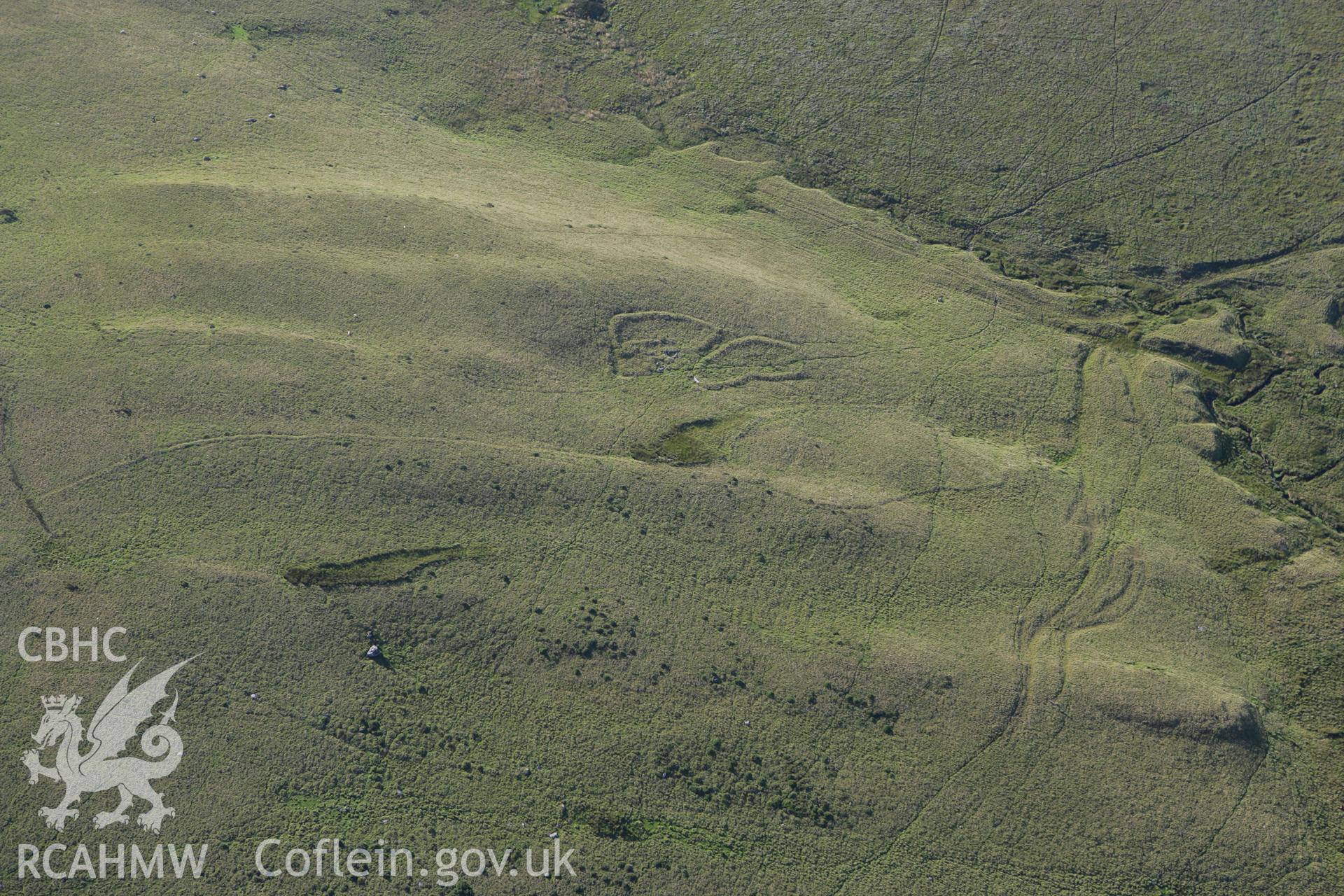 RCAHMW colour oblique aerial photograph of a deserted farmstead south of Ffynnon Yr Oerfa. Taken on 08 August 2007 by Toby Driver