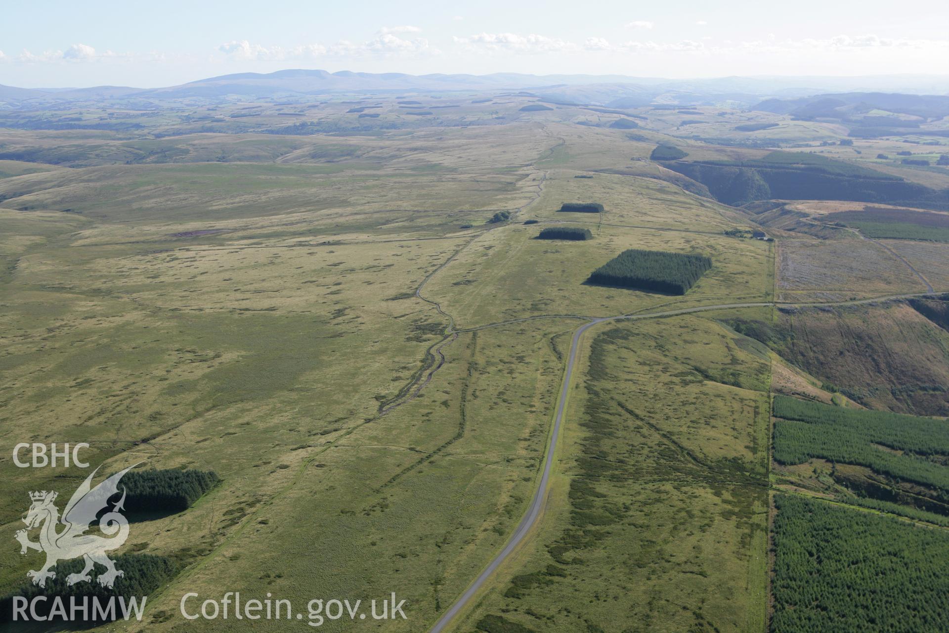 RCAHMW colour oblique aerial photograph of Tri Chrugiau Cairn I, II, III and surrounding landscape, viewed from the north-east. Taken on 08 August 2007 by Toby Driver