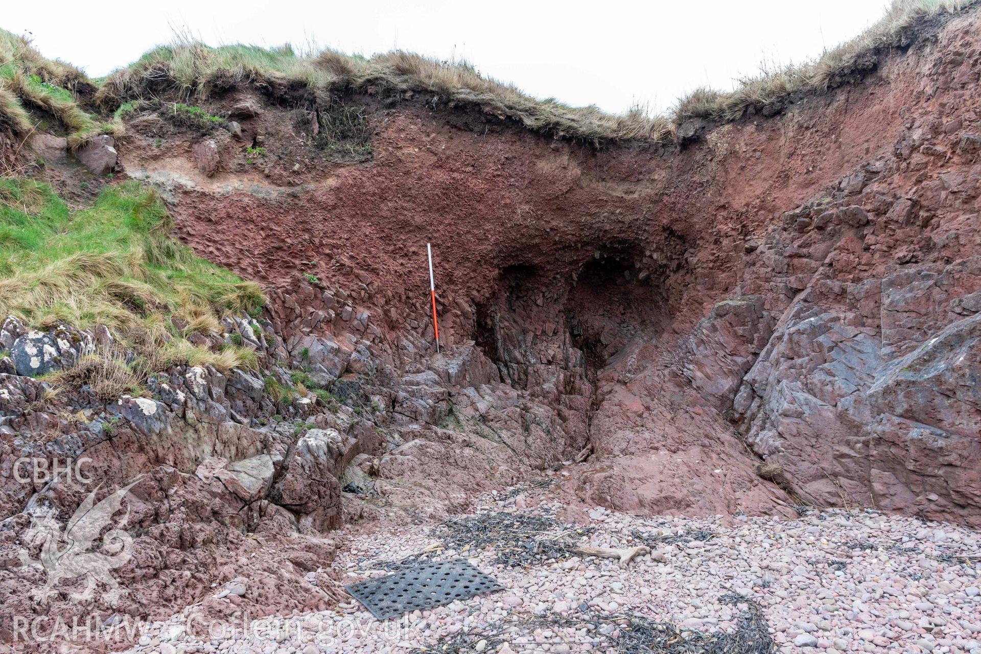 View of erdoing coast with undercut and exposed cemetery remains (with scale).
