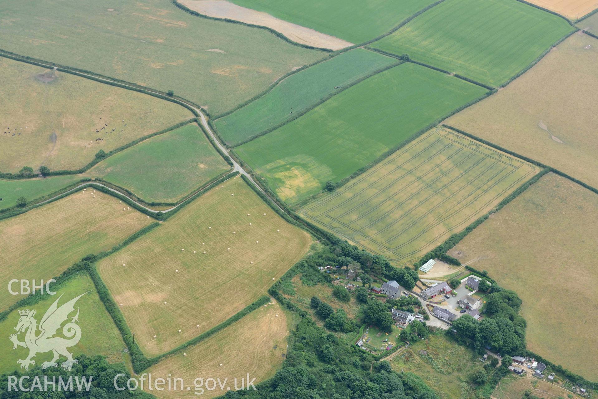 RCAHMW colour oblique aerial photograph of Woodlands Farm defended enclosure from NW taken on 11 July 2018 by Toby Driver