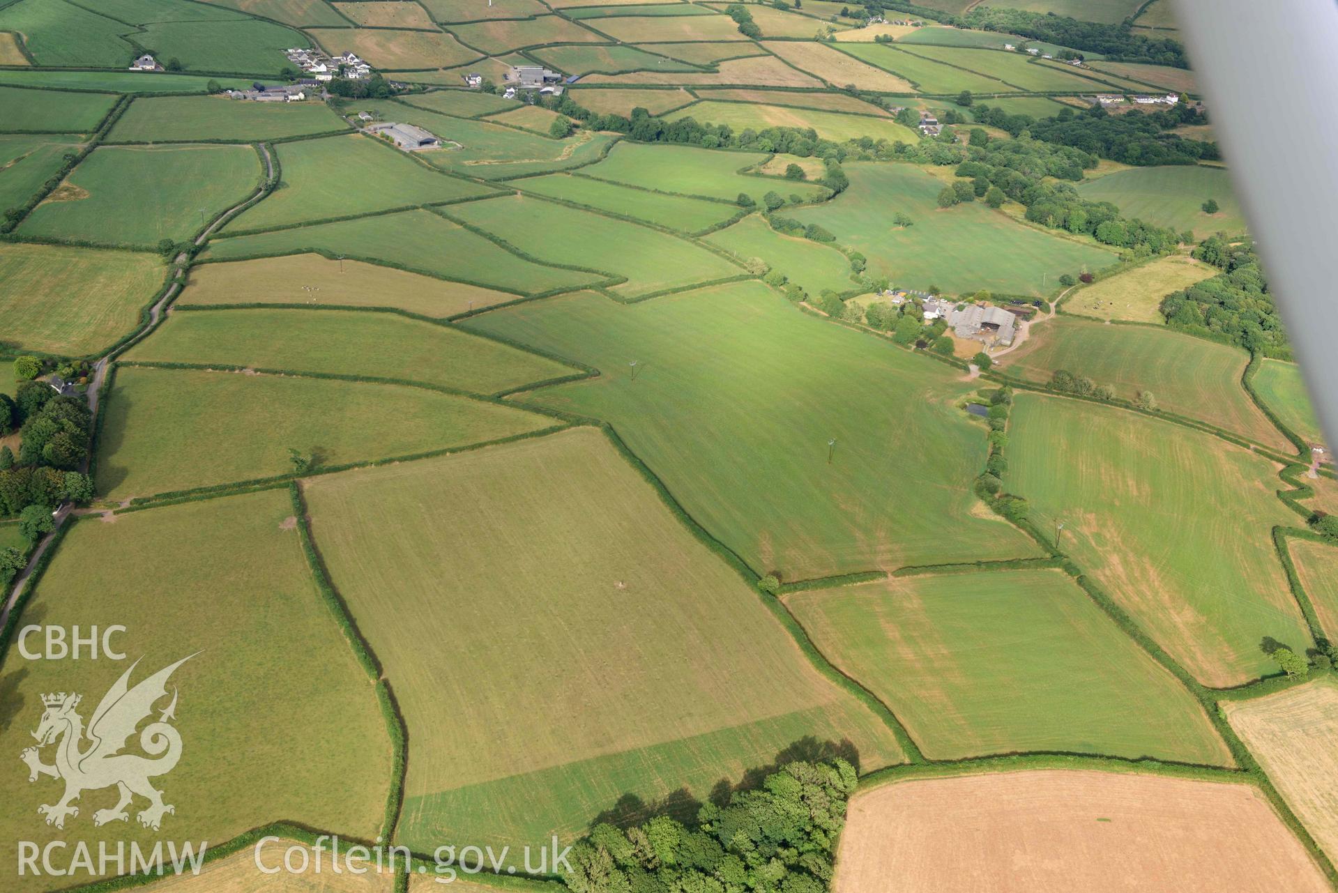 RCAHMW colour oblique aerial photograph of Roman road from Carmarthen to Kidwelly; quarry pit cropmarks west of Fforest-uchaf, view from SW taken on 17 July 2018 by Toby Driver (NGR: SN412144)