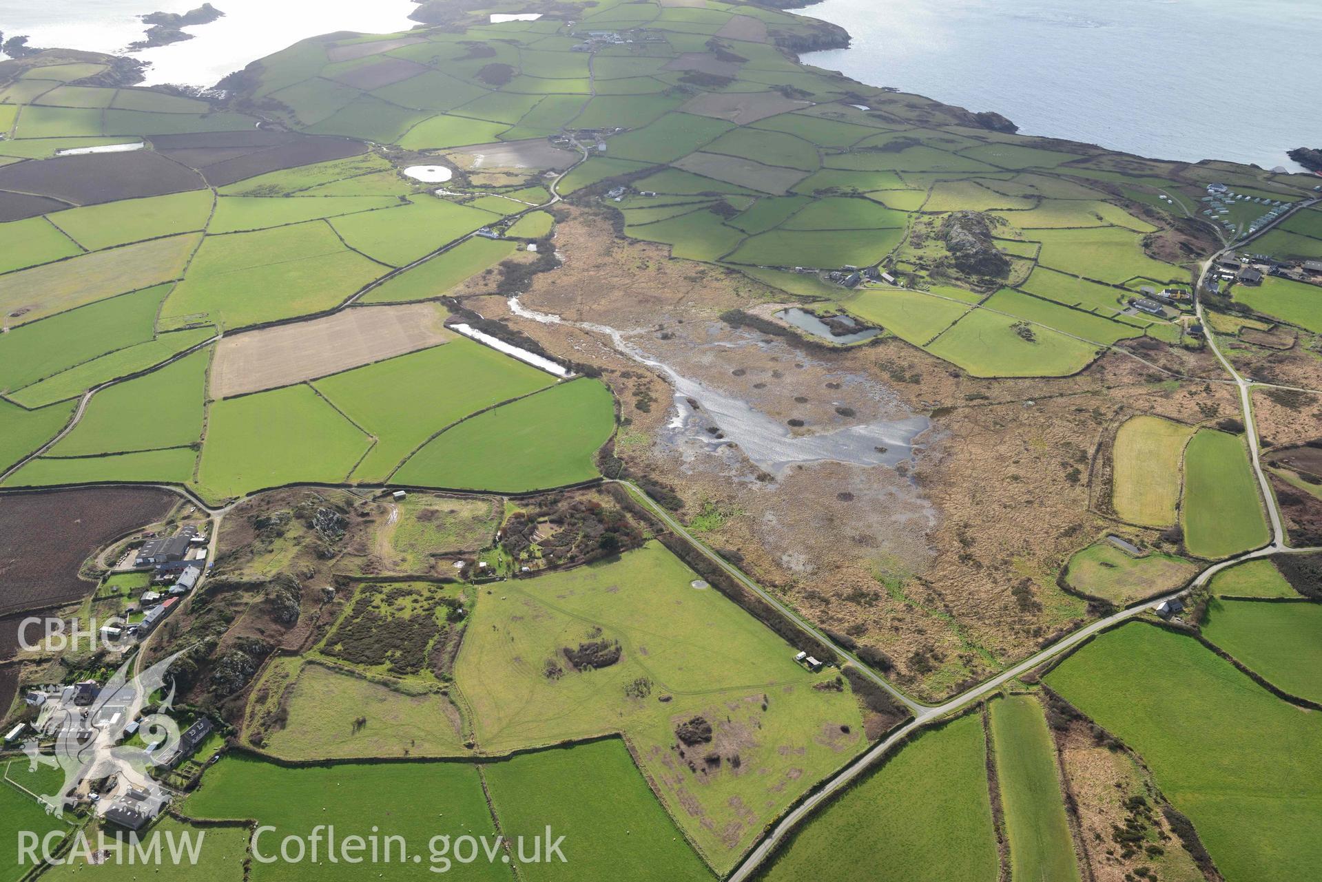 RCAHMW colour oblique aerial photograph of Clegyr-Boia defended settlement, with Pwll Trefeiddan wetland to W taken on 4 March 2022 by Toby Driver ((SM737250)