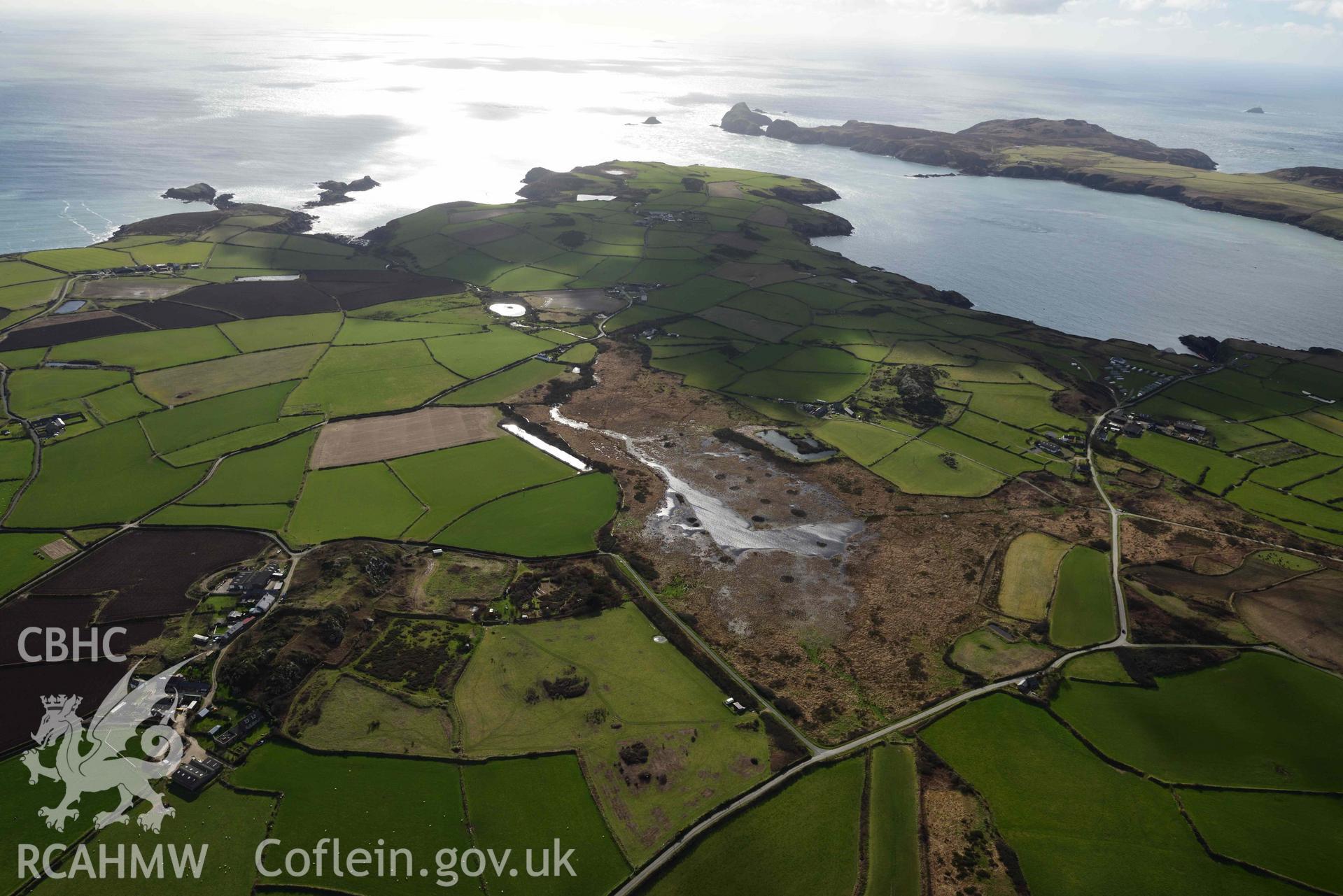 RCAHMW colour oblique aerial photograph of Clegyr-Boia defended settlement, with Pwll Trefeiddan wetland to W taken on 4 March 2022 by Toby Driver ((SM737250)