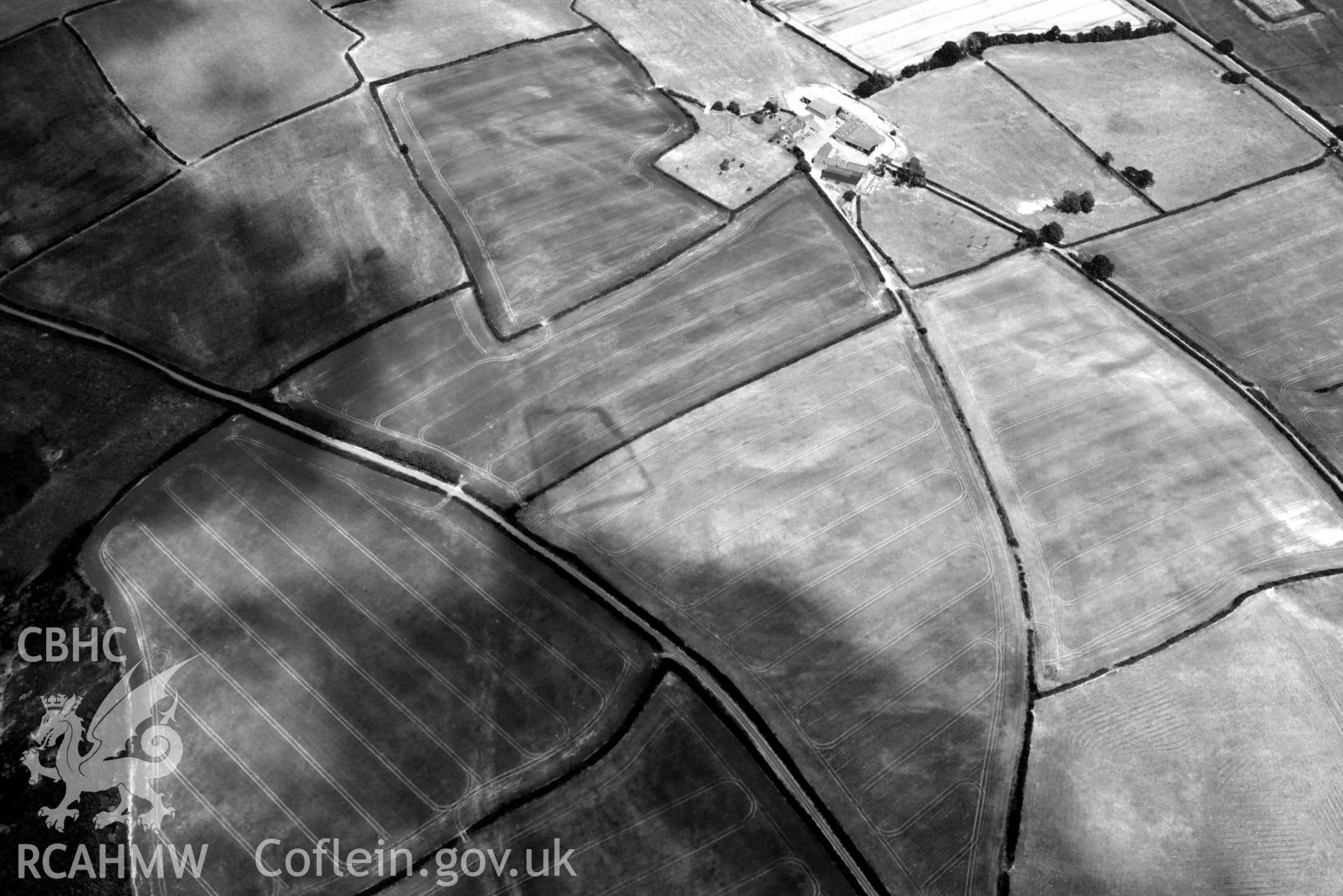 RCAHMW black and white oblique aerial photograph of Court Llacca cropmark taken on 9 July 2018 by Toby Driver