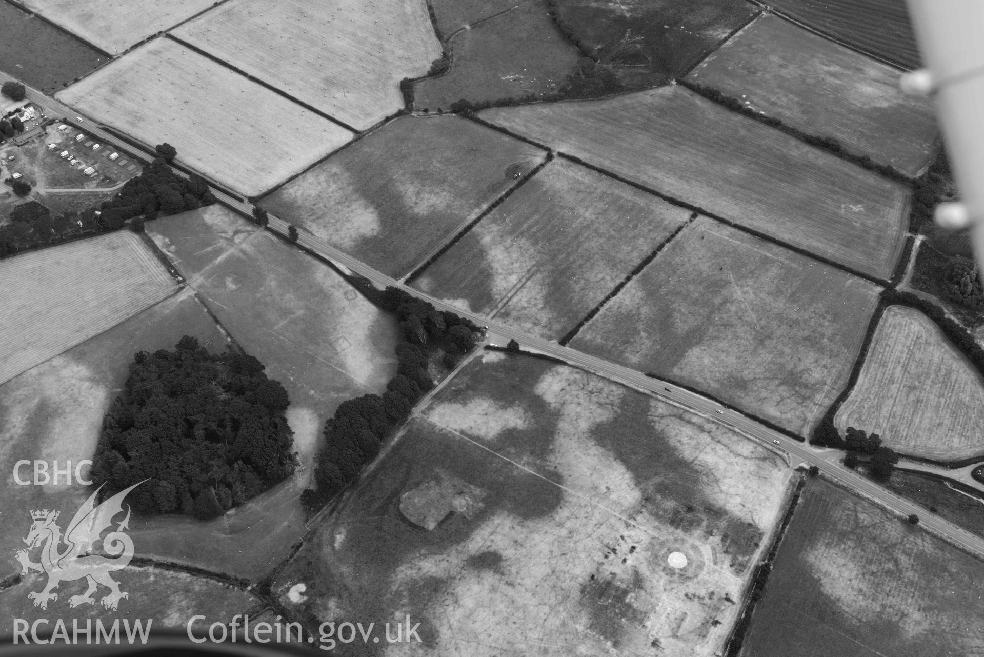 Aerial photograph: Croes Faen, cropmarks of square barrow cemetery; wide view from west with parchmarks of funfair to west. Crown: CHERISH PROJECT 2018. Produced with EU funds through the Ireland Wales Co-operation Programme 2014-2020 (NGR SH598018)