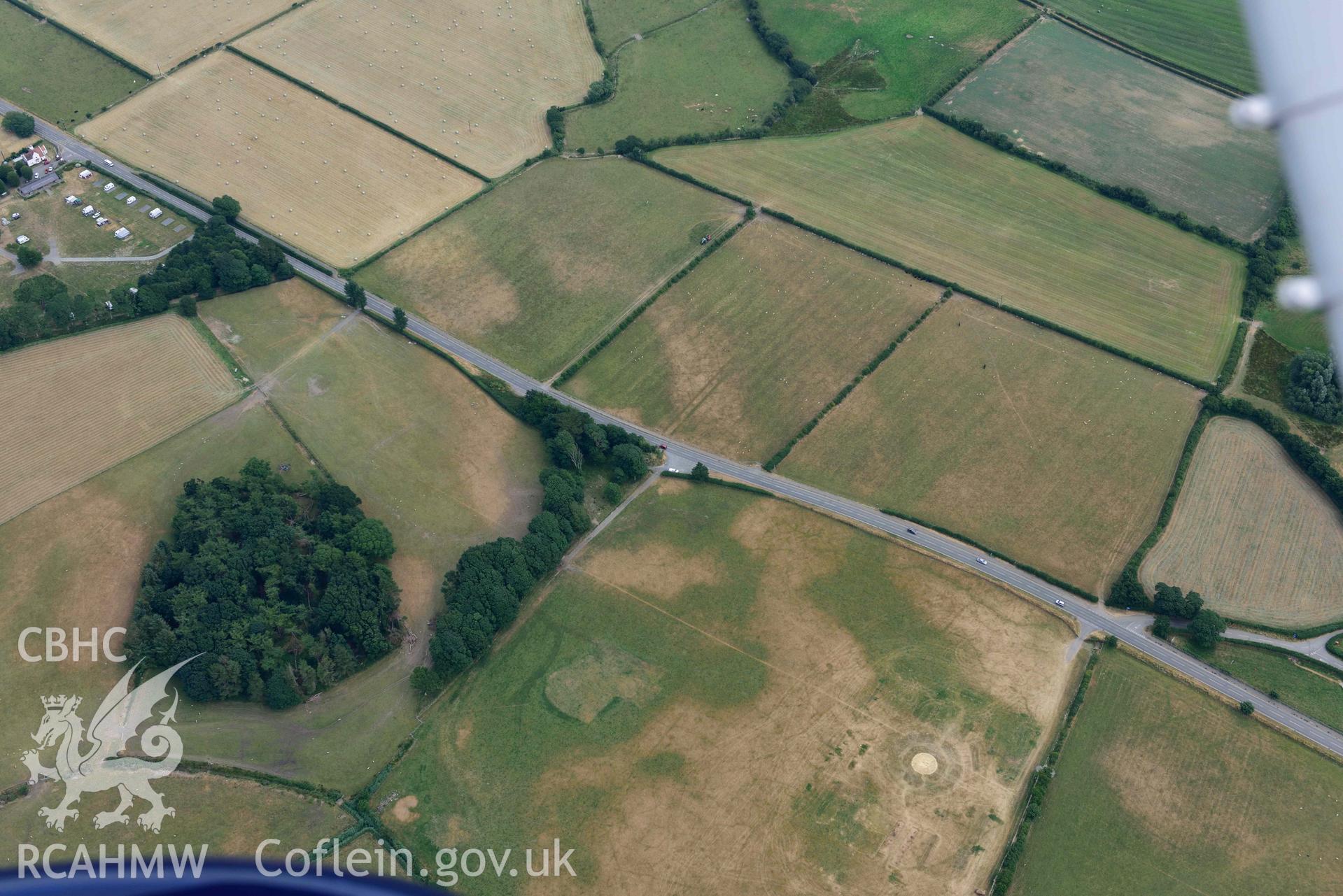 Aerial photograph: Croes Faen, cropmarks of square barrow cemetery; wide view from west with parchmarks of funfair to west. Crown: CHERISH PROJECT 2018. Produced with EU funds through the Ireland Wales Co-operation Programme 2014-2020 (NGR SH598018)