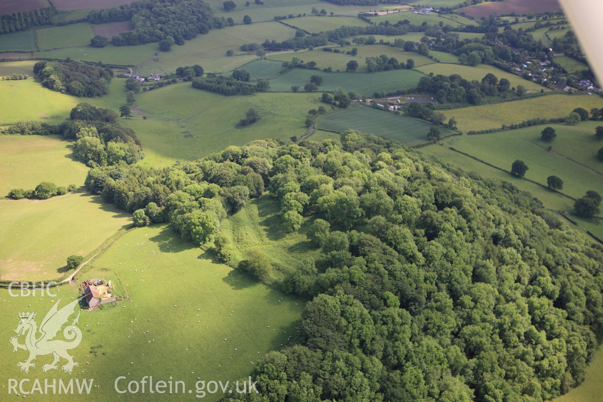 RCAHMW colour oblique aerial photograph of Coed-y-Bwnyff Enclosure (Coed y Bwynydd Camp). Taken on 11 June 2009 by Toby Driver