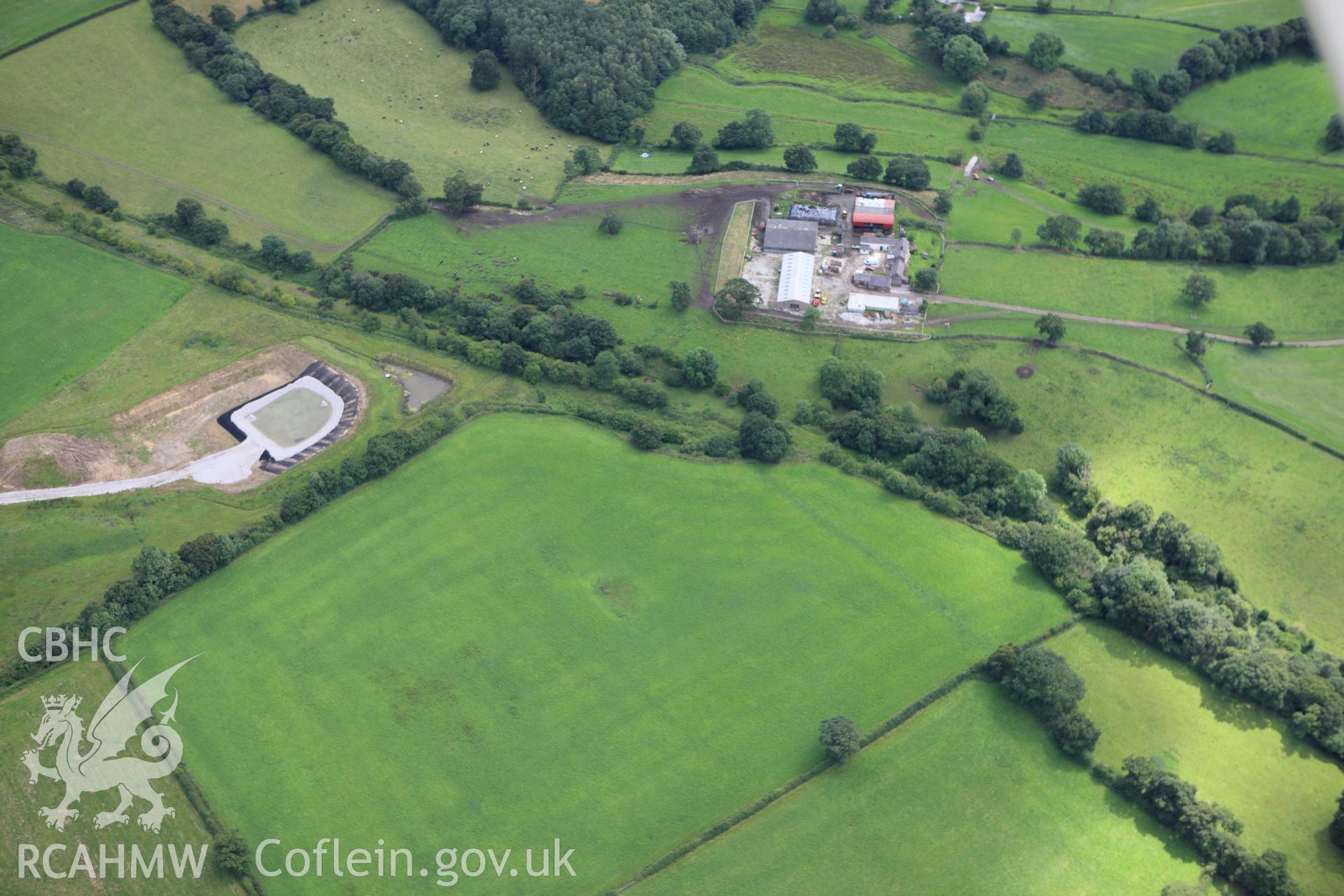 RCAHMW colour oblique aerial photograph of Wat's Dyke east of Padeswood, showing as a cropmark in a ploughed area. Taken on 30 July 2009 by Toby Driver