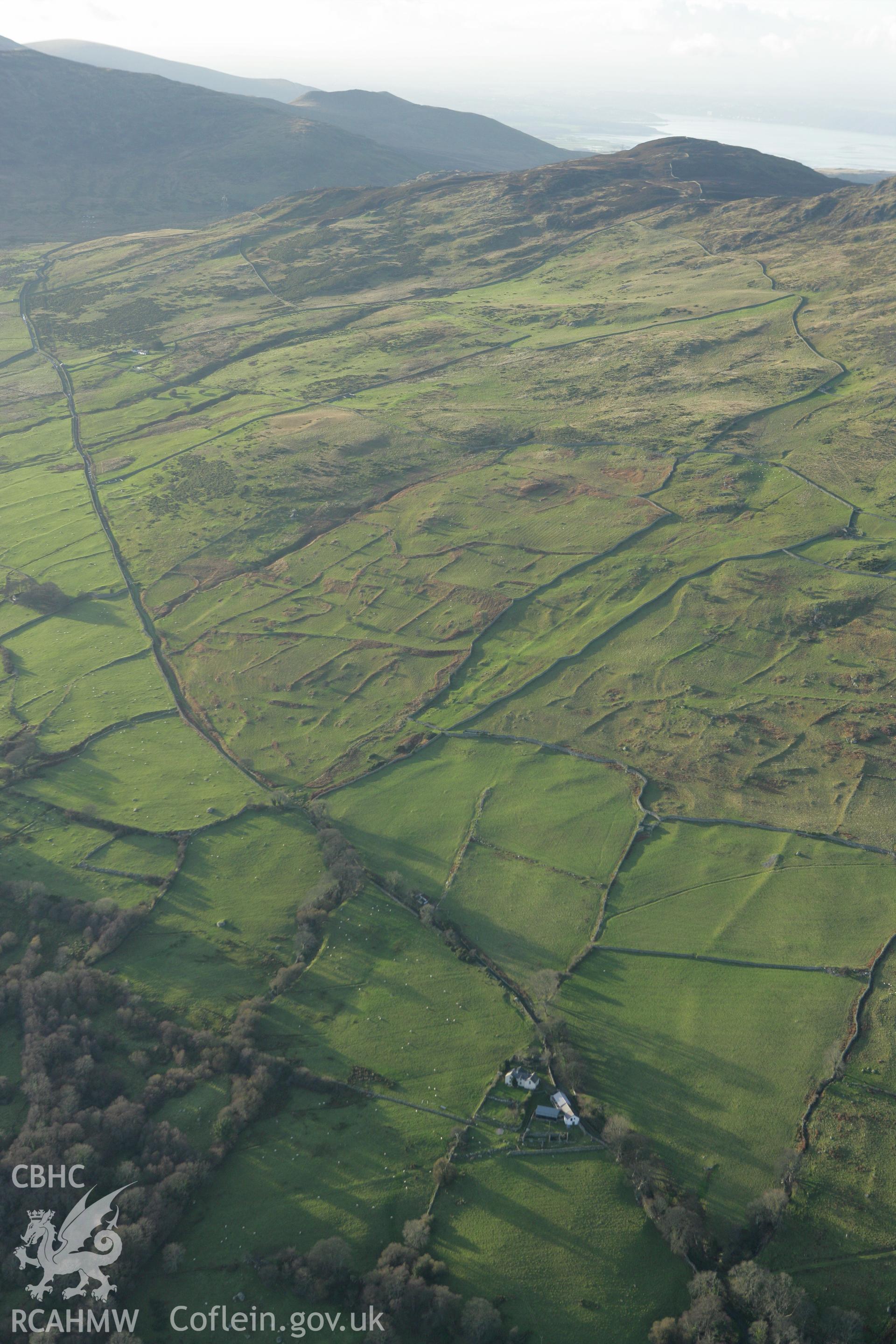 RCAHMW colour oblique aerial photograph of Maen-y-Bardd Settlement and field systems, in landscape from south-east Taken on 10 December 2009 by Toby Driver