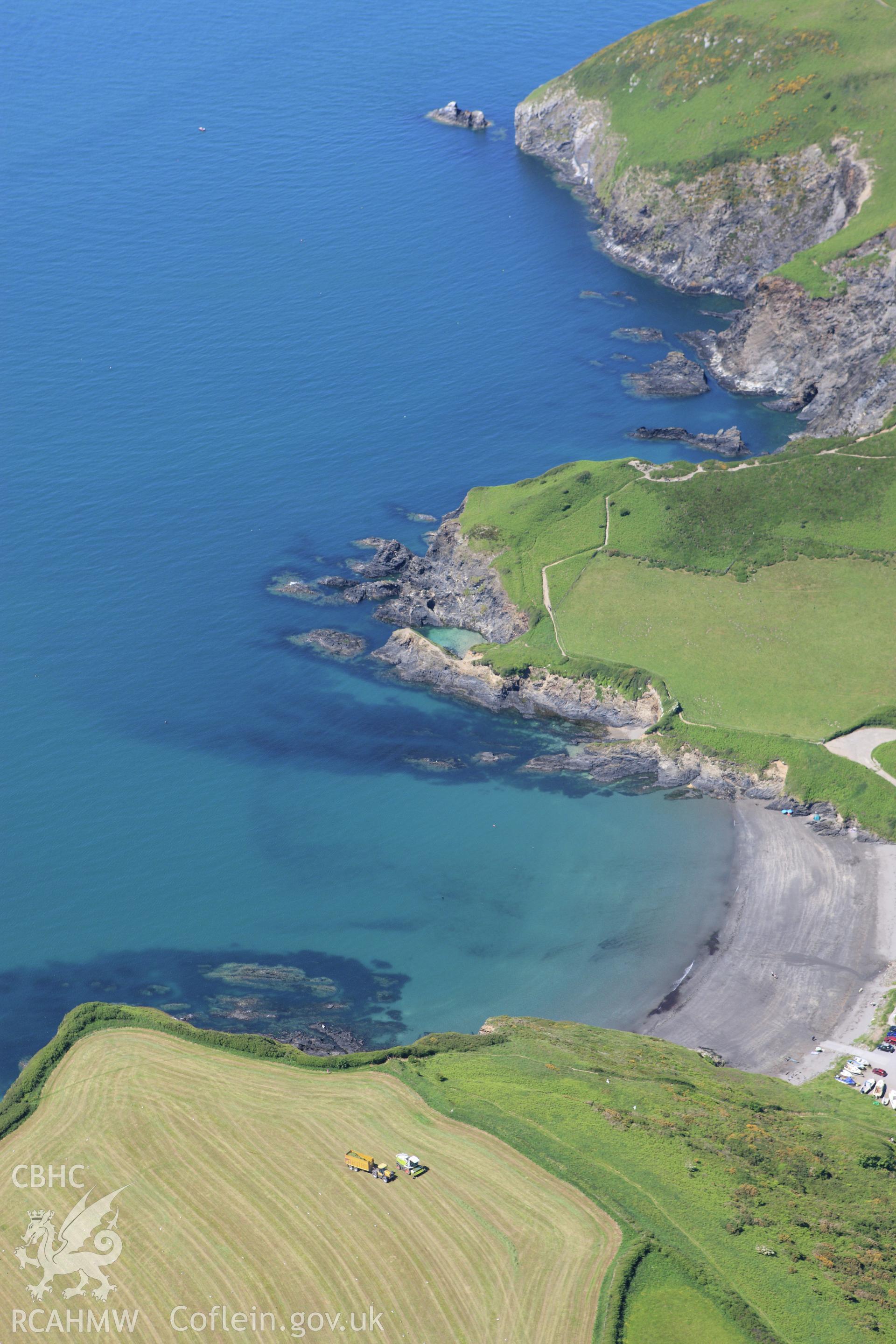 RCAHMW colour oblique aerial photograph of Pen Castell, Dinas Island showing Pwllgwaelod beach. Taken on 01 June 2009 by Toby Driver