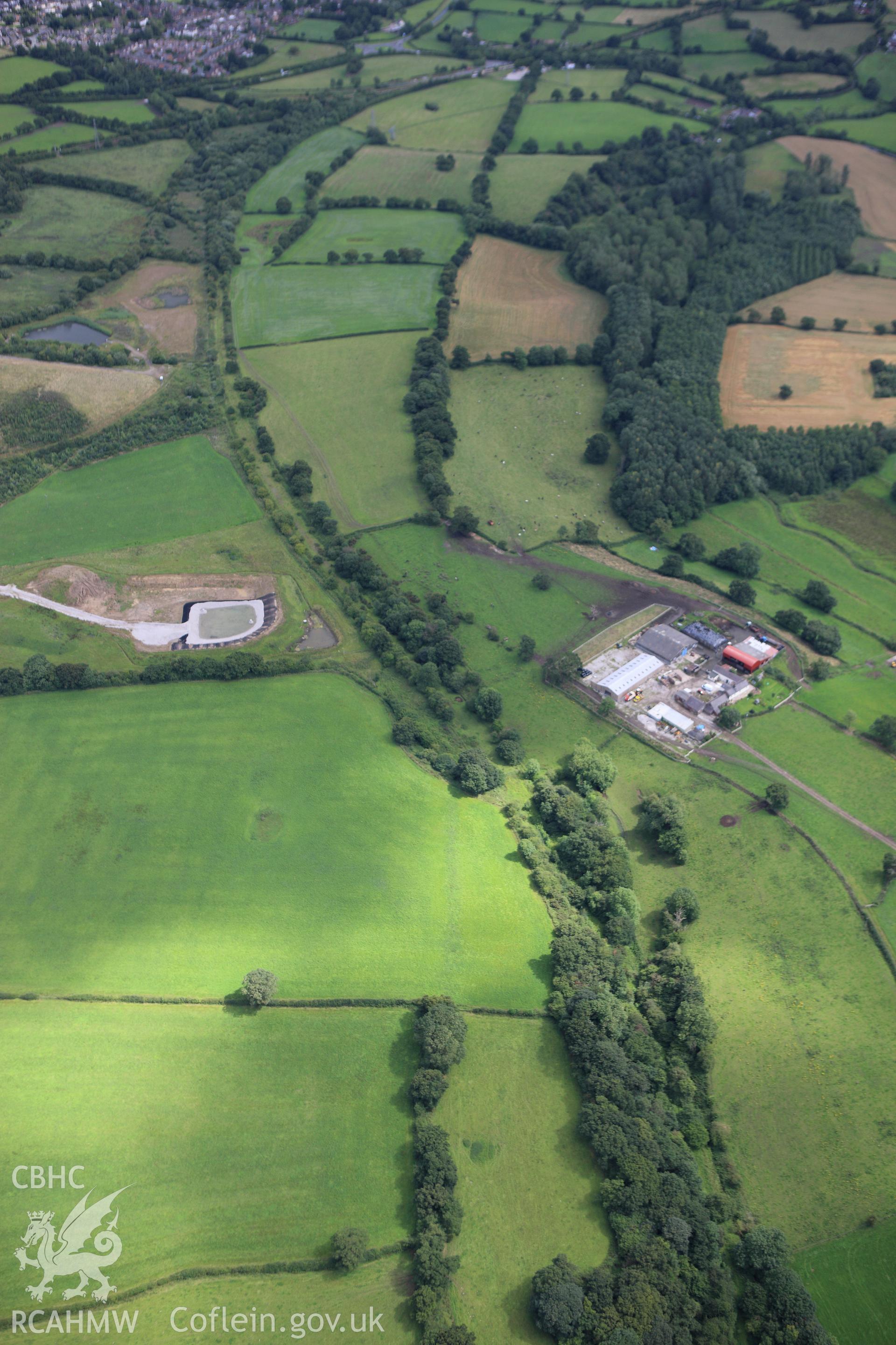 RCAHMW colour oblique aerial photograph of Wat's Dyke east of Padeswood, showing as a cropmark in a ploughed area, looking south-east. Taken on 30 July 2009 by Toby Driver