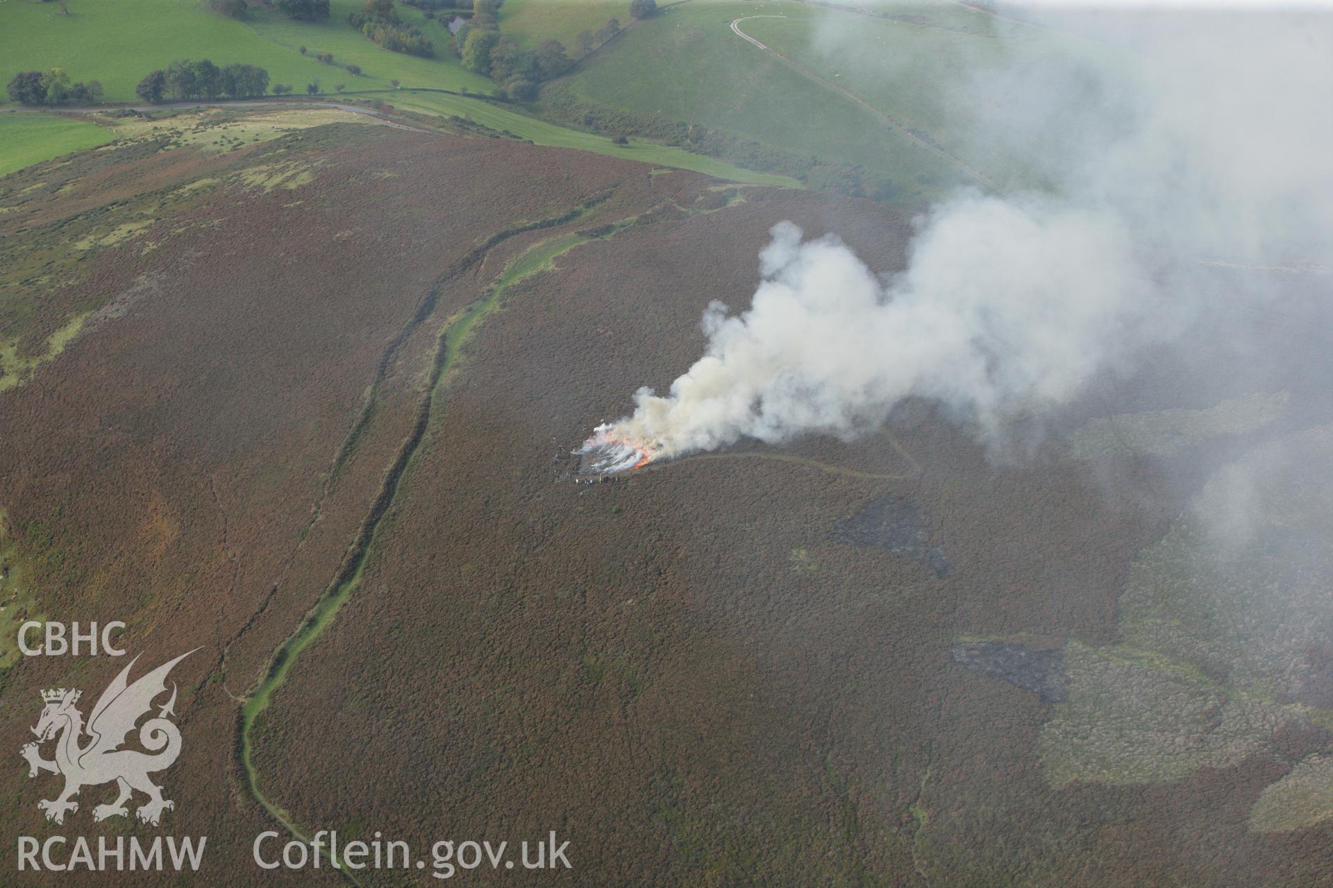 RCAHMW colour oblique aerial photograph of Foel Fenlli Hillfort showing a controlled heather burn. Taken on 13 October 2009 by Toby Driver