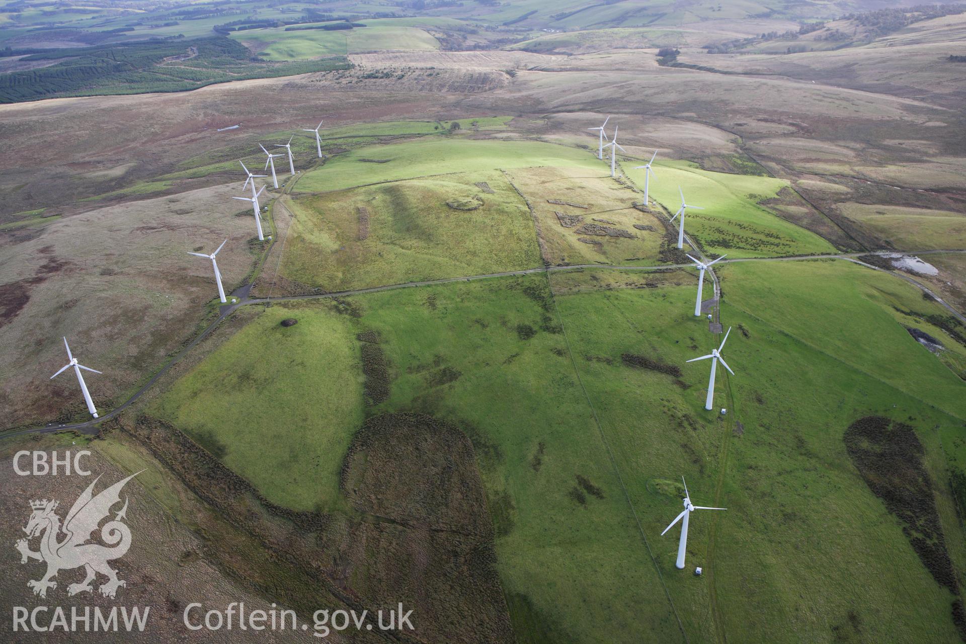 RCAHMW colour oblique aerial photograph of Pegwyn Mawr Cairn I, in long view between turbines. Taken on 10 December 2009 by Toby Driver